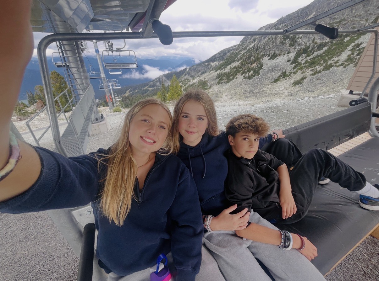 Josie and Chloe, the founders of Rooted, with a friend on a mountain chairlift